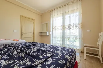 a bedroom with a bed and a large window at Reis Apartments in Ulcinj