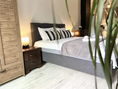 a bedroom with a bed and a table with a night stand at Panama apartment in Ulcinj