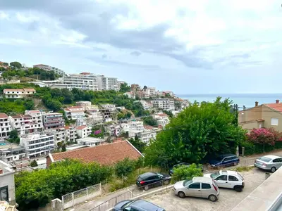 a city with cars parked in a parking lot at Panama apartment in Ulcinj