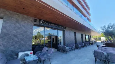 a building with chairs and tables outside of a store at Dulamerovic Hotel in Ulcinj
