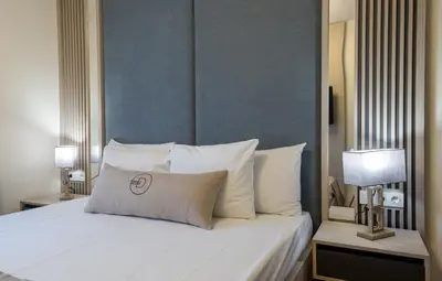 a bedroom with a bed with white pillows at Dulamerovic Hotel in Ulcinj