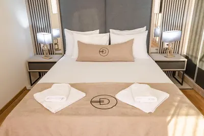 a bedroom with a bed with two towels on it at Dulamerovic Hotel in Ulcinj