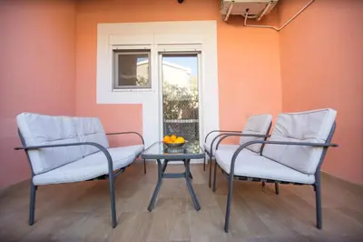 two chairs and a table in front of a window at Apartments Kovačević in Petrovac na Moru