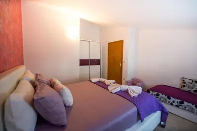 a bedroom with a large bed with pillows on it at Apartments Kovačević in Petrovac na Moru