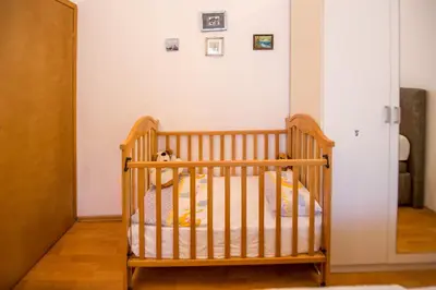 a crib in a room with a white wall at Apartments Kovačević in Petrovac na Moru