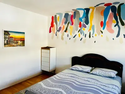 a bedroom with a bed and a painting on the wall at City Center Square DeLuxe Nest in Podgorica