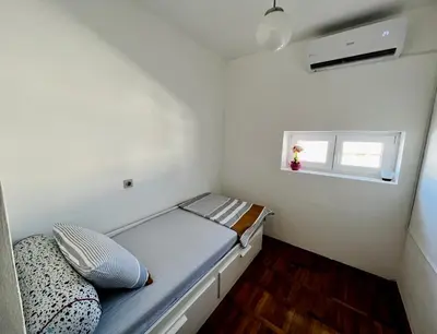 a small bedroom with a bed and a window at City Center Square DeLuxe Nest in Podgorica