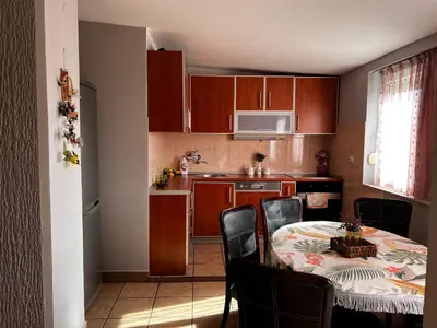 a kitchen with a table and chairs and a kitchen with brown cabinets at City Center Square DeLuxe Nest in Podgorica