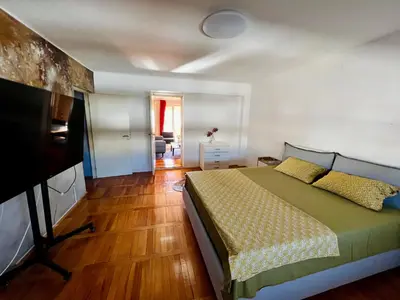 a bedroom with a bed and a flat screen tv at City Center Square DeLuxe Nest in Podgorica