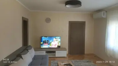 a living room with a couch and a flat screen tv at Prestige in Podgorica