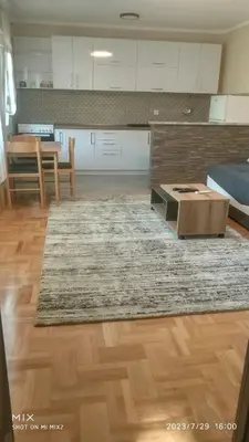a living room with a table and a kitchen at Prestige in Podgorica
