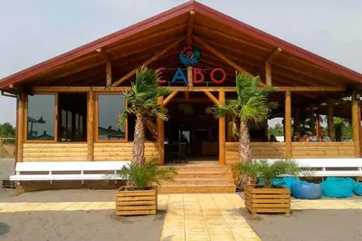 a restaurant with palm trees in front of a building at Apartment Nafija. No 2 in Donji Štoj