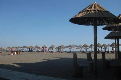 a beach with umbrellas and chairs on the sand at Apartment Nafija. No 2 in Donji Štoj