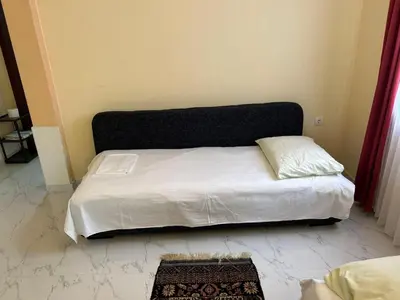 a white bed with a black headboard in a room at Apartment Nafija. No 2 in Donji Štoj