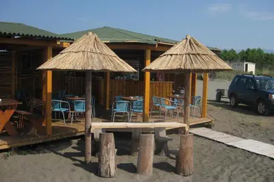 a pavilion with chairs and tables and umbrellas at Apartment Nafija. No 2 in Donji Štoj