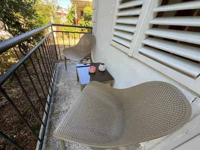 a balcony with a rattan chair and a table at Casa Cristiano in Sutomore