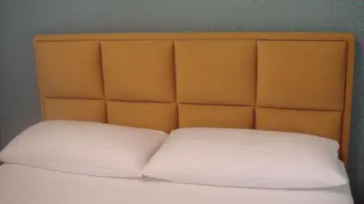 a bed with two white pillows and an orange headboard at Casa Cristiano in Sutomore