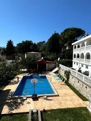 a swimming pool in front of a white building at Sunset Pool Retreat in Zagrađe