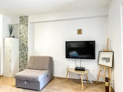 a living room with a chair and a flat screen tv at Apartment Anita - Budva in Budva