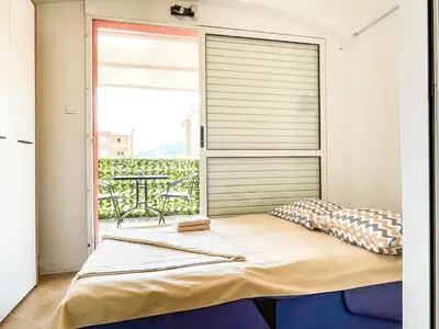 a bed in a room with a large window at Apartment Anita - Budva in Budva