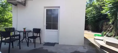 a patio with a table and chairs and a door at Rijeka Crnojevica Apartment Vujovic in Rijeka Crnojevića