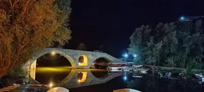 a stone bridge over a river at night at Rijeka Crnojevica Apartment Vujovic in Rijeka Crnojevića