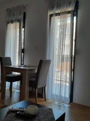 a room with a table and chairs and a window at Apartman Podgorica in Podgorica