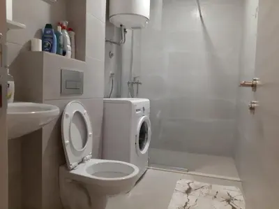 a white bathroom with a toilet and a shower at Apartman Podgorica in Podgorica