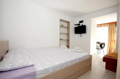 a bedroom with a large bed and a tv at Apartments Pavlovic in Petrovac na Moru