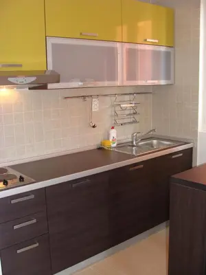 a kitchen with brown cabinets and a sink at Alessandra Apartments in Sveti Stefan