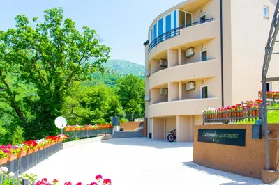 a building with flowers in front of it at Alessandra Apartments in Sveti Stefan
