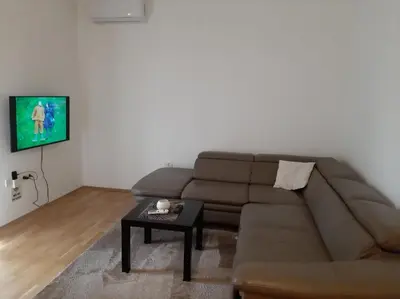 a living room with a brown couch and a table at Apartment Podgorica in Podgorica