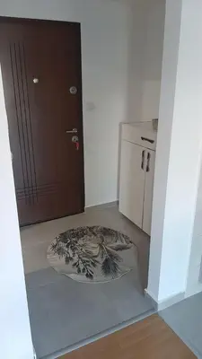 a room with a door and a rug next to a refrigerator at Apartment Podgorica in Podgorica