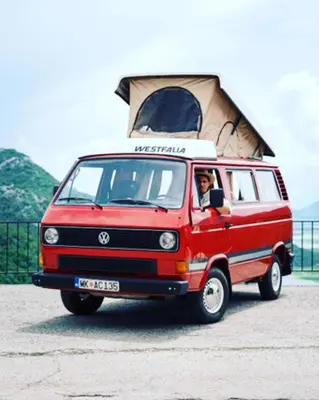 a man driving a red van with a pitched roof at Mobile home - Alpha Campers Montenegro - Our Red Westfalia Bus in Podgorica