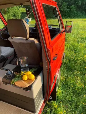 an open back seat of a car with a plate of fruit at Mobile home - Alpha Campers Montenegro - Our Red Westfalia Bus in Podgorica