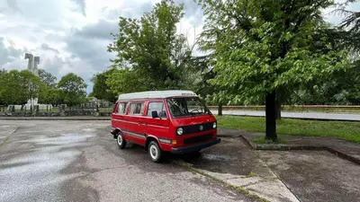 a small red van parked in a parking lot at Mobile home - Alpha Campers Montenegro - Our Red Westfalia Bus in Podgorica