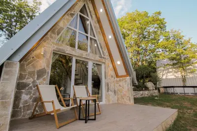a house with two chairs on a deck at Vukova dolina apartments in Cetinje