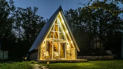 a tiny house with a gambrel roof and a large window at Vukova dolina apartments in Cetinje