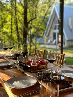 a wooden table with plates and glasses of wine at Vukova dolina apartments in Cetinje