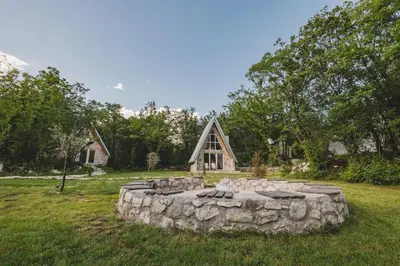 a stone fire pit in front of a cabin at Vukova dolina apartments in Cetinje