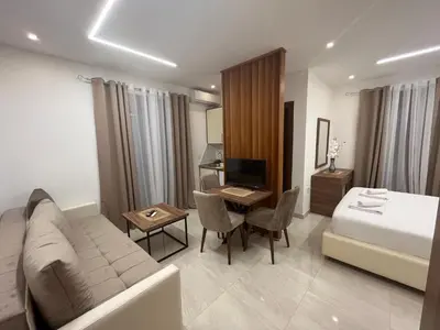a hotel room with a couch and a bed and a desk at Arbneshi Apartments in Ulcinj