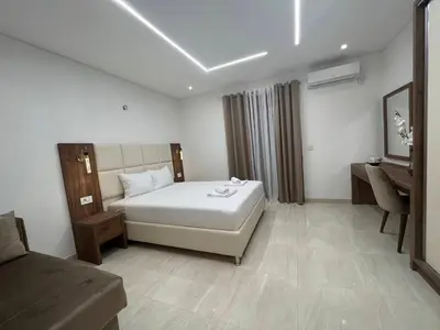 a bedroom with a bed and a desk and a chair at Arbneshi Apartments in Ulcinj
