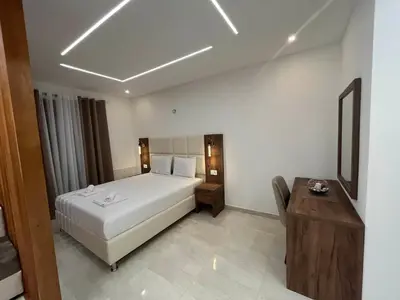 a hotel room with a bed and a desk and a bed sidx sidx at Arbneshi Apartments in Ulcinj