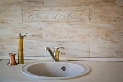a sink in a bathroom with a sign on the wall at Bell Tower Apartment in Budva