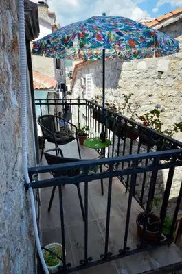 a balcony with a table and an umbrella at Bell Tower Apartment in Budva