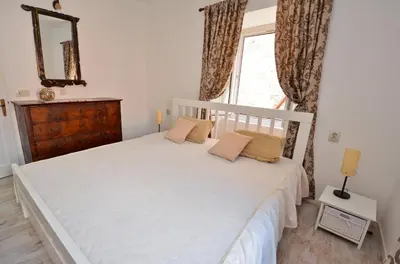 a bedroom with a white bed and a window at Bell Tower Apartment in Budva