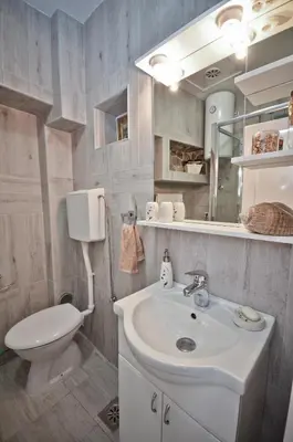 a bathroom with a white sink and a toilet at Bell Tower Apartment in Budva