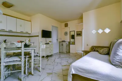 a room with a bed and a desk and a television at Sea Paradise Apartment in Budva