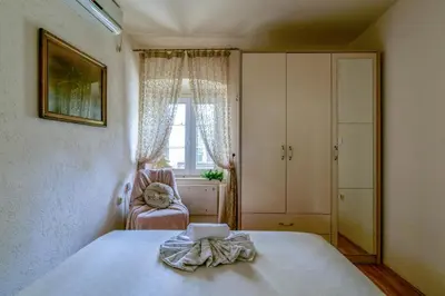 a bedroom with a bed and a chair and a window at Sea Paradise Apartment in Budva