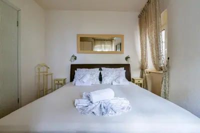a bedroom with a bed with white sheets and pillows at Sea Paradise Apartment in Budva